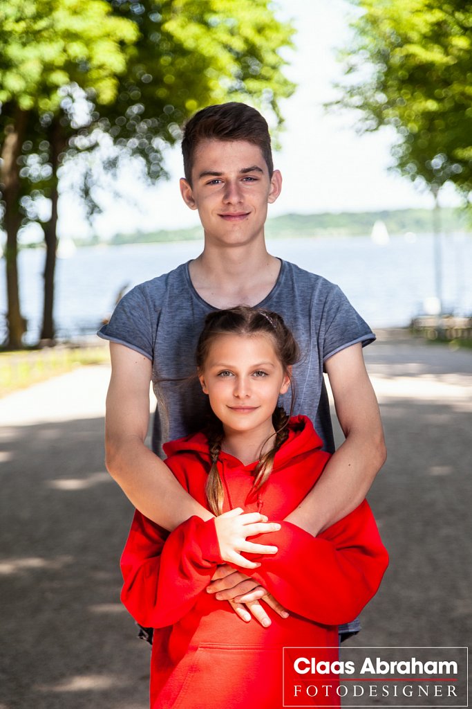 Zwei Kinder bei einem Fototermin draußen im Park