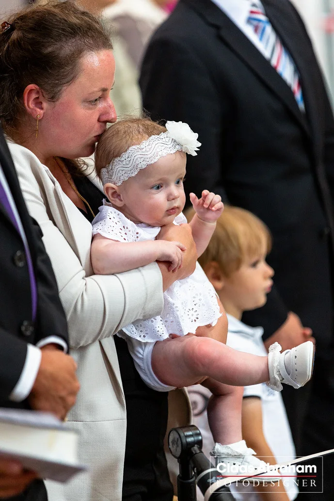 Kind während eines Taufgottesdienstes im Kreis der Familie.